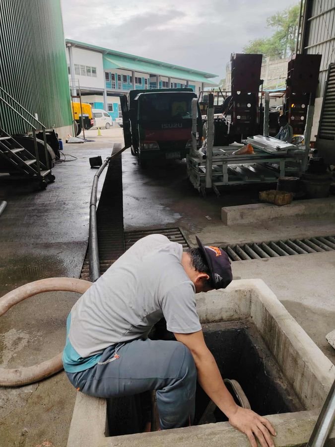 Technician inspecting a septic access point